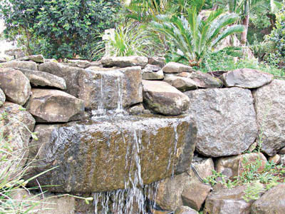 Moving water  over rocks splashing into pond