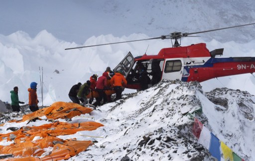 An injured person is loaded onto a rescue helicopter at Everest Base Camp on April 26, 2015, a day after an avalanche triggered by an earthquake devastated the camp. Rescuers in Nepal are searching frantically for survivors of a huge quake on April 25, that killed nearly 2,000, digging through rubble in the devastated capital Kathmandu and airlifting victims of an avalanche at Everest base Camp. The bodies of those who perished lie under orange tents. AFP PHOTO/ROBERTO SCHMIDT