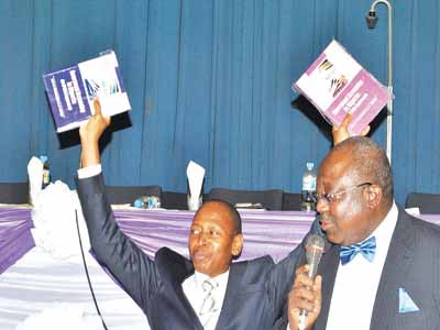 Attorney-General of the Federation, Mr. Ahmed Idris presenting the book while Permanent Secretary, Ministry of Communication and Technology speaks at the book presentation recently