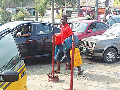 Fully ‘armed’ with four jerry cans and rolled up pair of trousers, a prospective buyer ‘storms’ a filling station, flanked by ‘armoured’ cars.