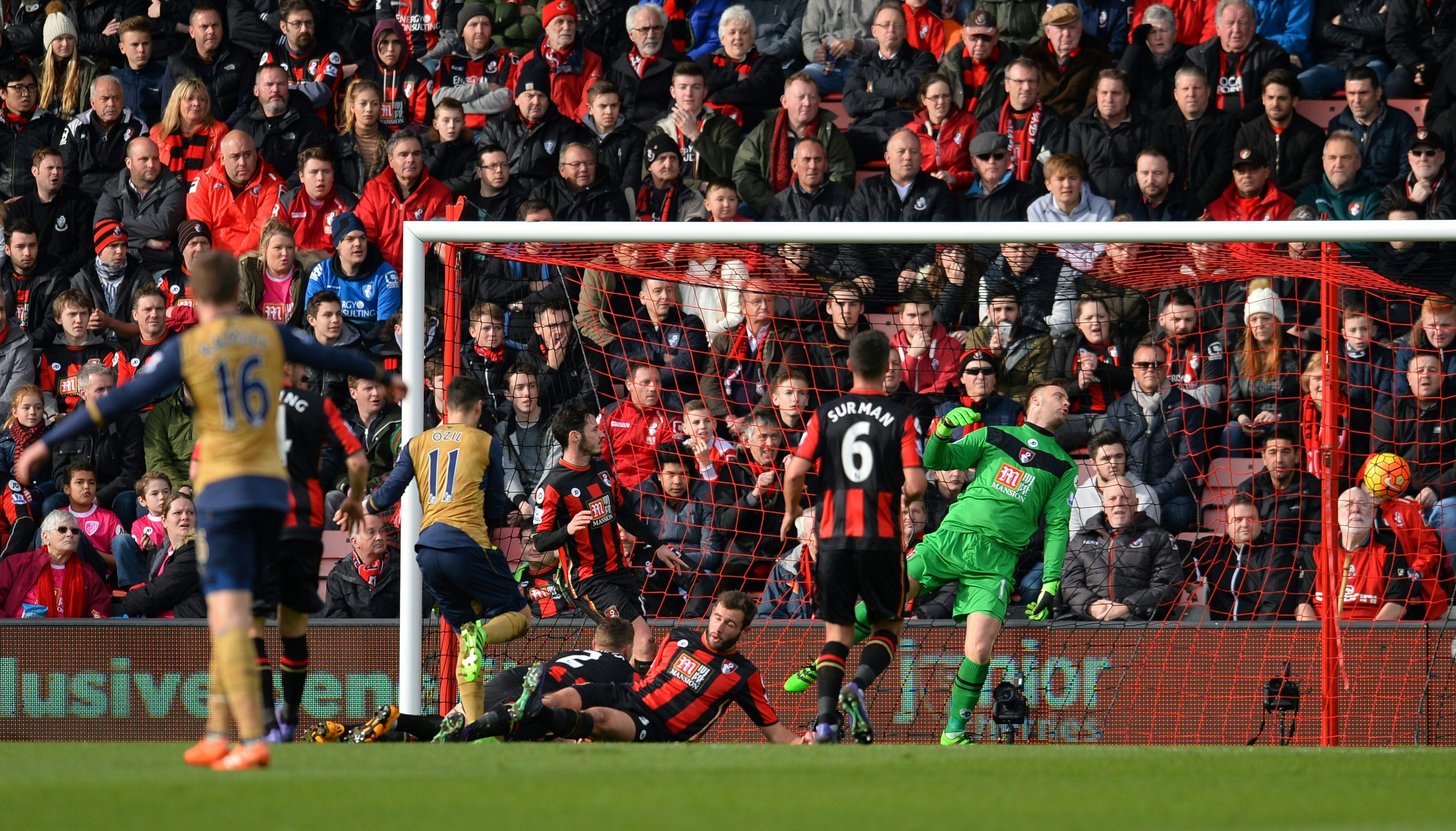 Arsenal's German midfielder Mesut Ozil (2l) scores his team's first goal during the English Premier League football match between Bournemouth and Arsenal at the Vitality Stadium in Bournemouth, southern England on February 7, 2016. / AFP / GLYN KIRK / RESTRICTED TO EDITORIAL USE. No use with unauthorized audio, video, data, fixture lists, club/league logos or 'live' services. Online in-match use limited to 75 images, no video emulation. No use in betting, games or single club/league/player publications. /