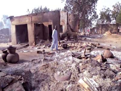 A man walks past burnt out houses following an attack by Boko Haram in the village of Dalori village five kilometers (three miles) from Maiduguri, Jan. 31, 2016. (Source: Time)