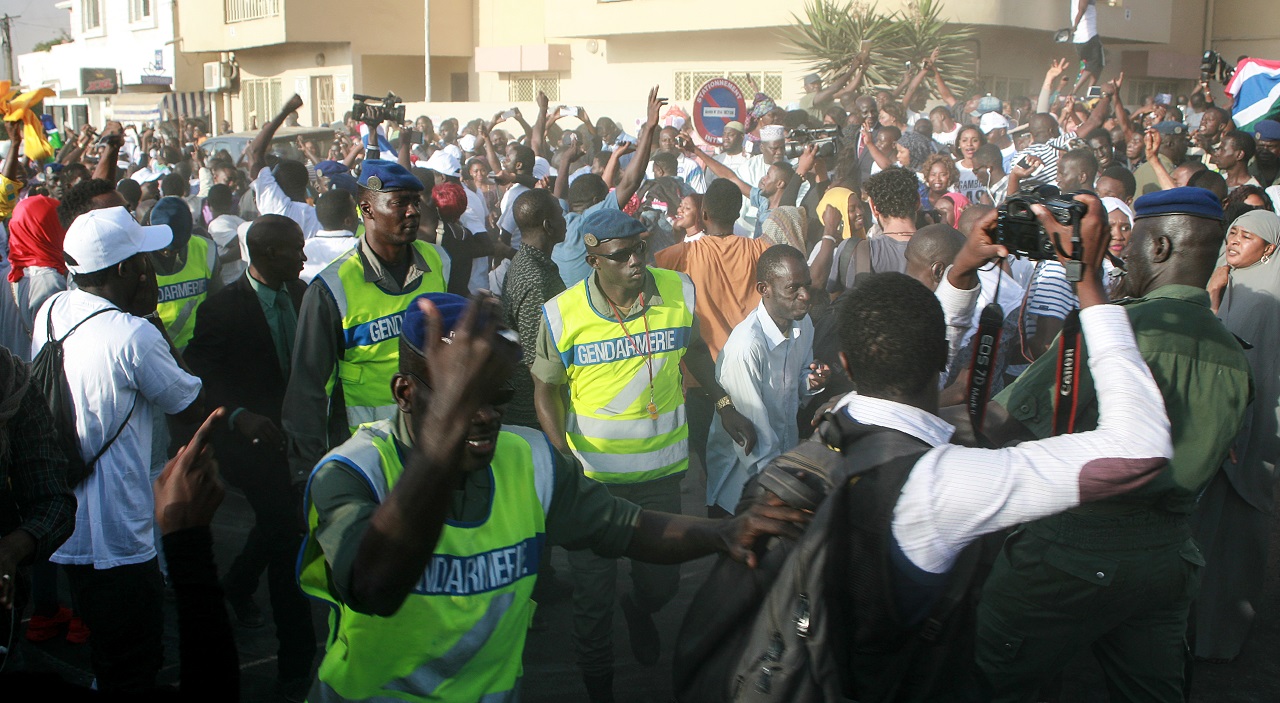 Gendarmes interfere as supporters celebrate Gambia's President-elect Adama Barrow in front of the Gambian Embassy in Dakar on January 19, 2017. Gambia's new president Adama Barrow took the oath of office in the country's embassy in Senegal on January 18, calling on the country's armed forces to "demonstrate their loyalty" in a standoff with Yahya Jammeh, the longtime leader who has refused to step down despite an election defeat. / AFP PHOTO / MOUSSA SOW