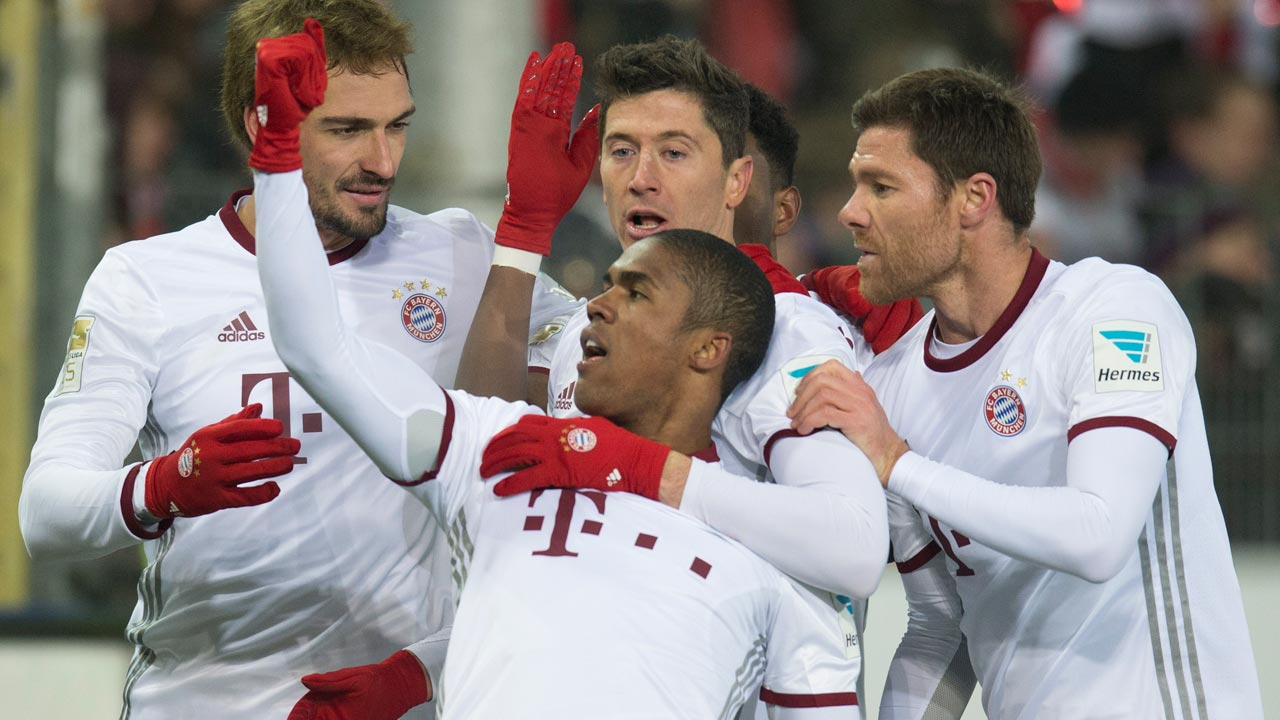 (L-R) Munich's defender Mats Hummels, Brazilian forward Douglas Costa, Polish forward Robert Lewandowski and Spanish midfielder Xabi Alonso celebrate after Lewandowski scored during the German first division Bundesliga football match SC Freiburg vs FC Bayern Munich in Freiburg, Germany, on January 20, 2017. THOMAS KIENZLE / AFP