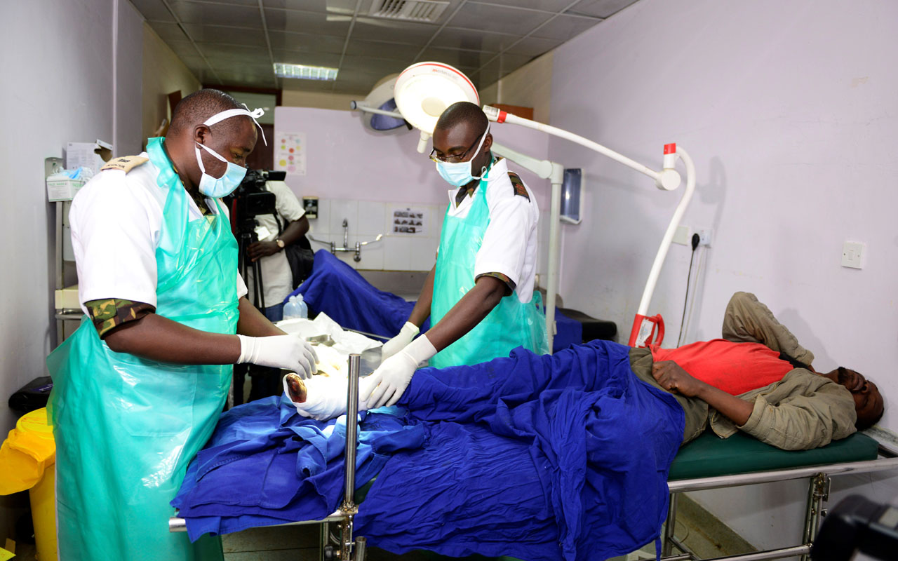 (FILES) This file photo taken on December 10, 2016 shows Kenyan Defence force (KDF) doctors attending to an injured man at Kenyatta National Hospital in Nairobi. A Kenyan court has handed down a one-month suspended jail term to seven union officials over a doctors' strike which has crippled public hospitals for the last 40 days. However Judge Hellen Wasilwa said that if the doctors did not call off the strike within two weeks, the officials would "be arrested and taken to jail." / AFP PHOTO / JOHN MUCHUCHA