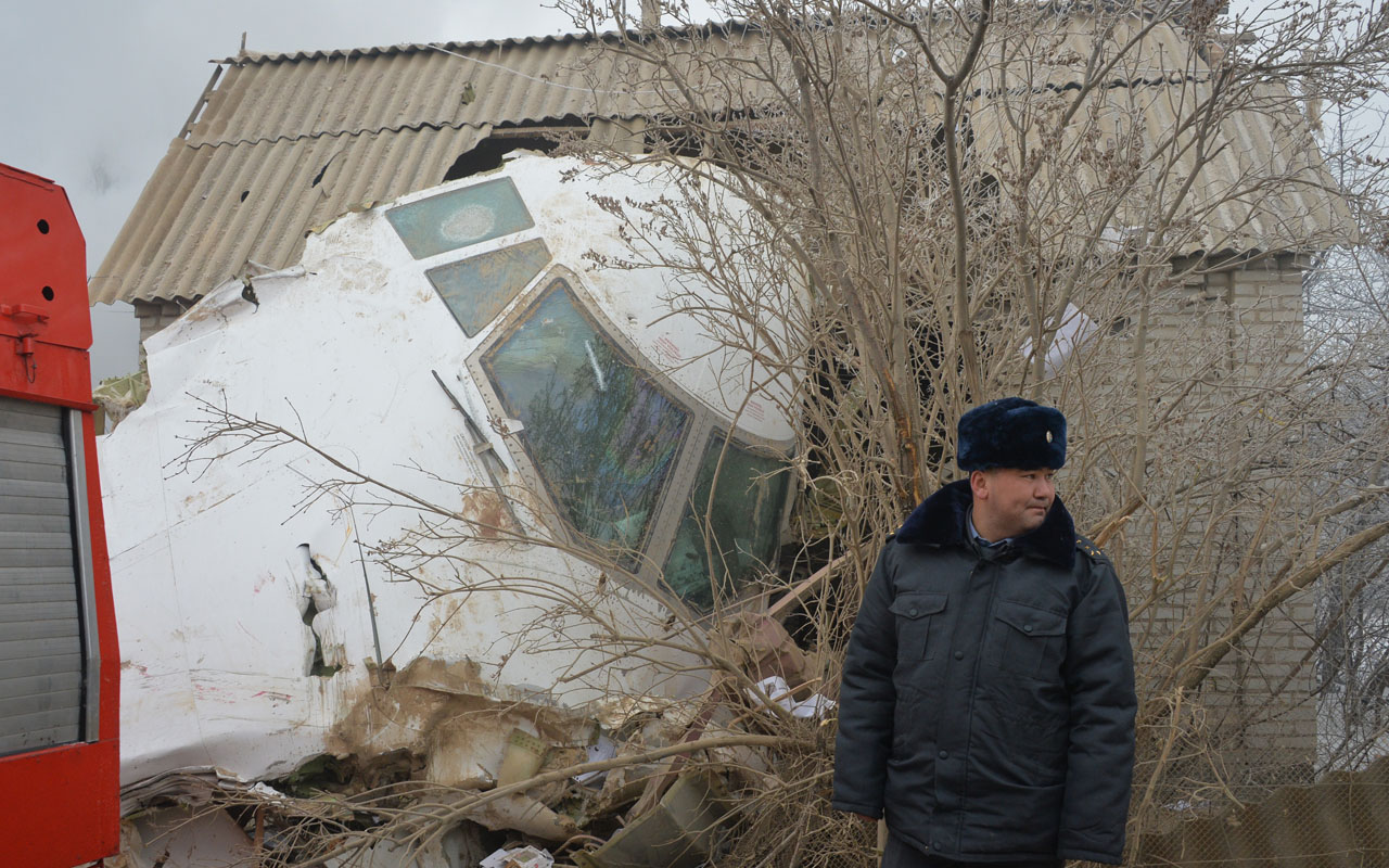 A police officer stands by the wreckage of a Turkish cargo plane at the crash site in the village of Dacha-Suu outside Bishkek on January 16, 2017. A Turkish cargo plane crashed into a village near Kyrgyzstan's main airport Monday, killing at least 37 people and destroying houses after attempting to land in thick fog, authorities said. / AFP PHOTO / Vyacheslav OSELEDKO