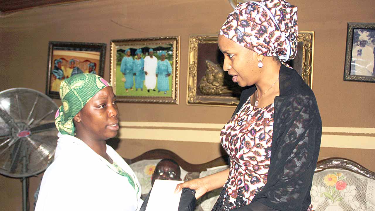 Usman (right) presenting cash to the widow, Mrs. Bakare