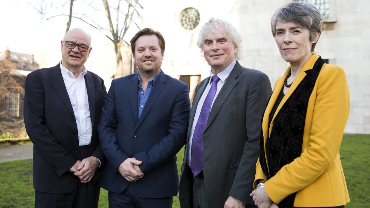 The London Symphony Orchestra's Music Director Designate, Simon Rattle (2R), poses for a photograph alongside London Symphony Orchestra Chairman Gareth Davies (2L), London Symphony Orchestra Managing Director Kathryn McDowell (R), and Barbican Centre Managing Director Nicholas Kenyon, following a press conference in London on January 17, 2017, where he announced plans for his opening season and future plans of the orchestra. Isabel INFANTES / AFP 