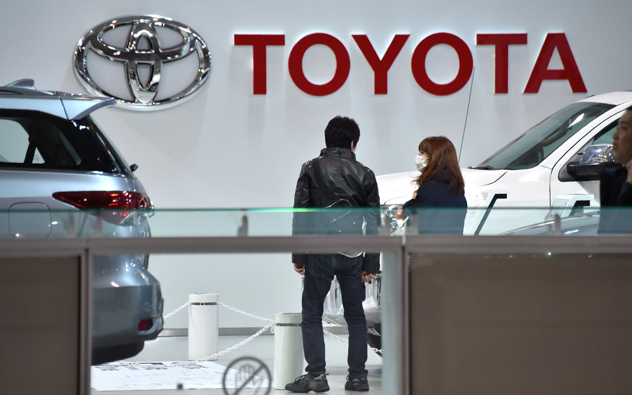 Visitors are seen in a showroom of Japan's Toyota Motor Corp. in Tokyo on January 6, 2017. Toyota shares fell on January 6 after US President-elect Donald Trump threatened the carmaker with tariffs over a new vehicle plant in Mexico, also prompting an objection from the Japanese government. / AFP PHOTO / Kazuhiro NOGI