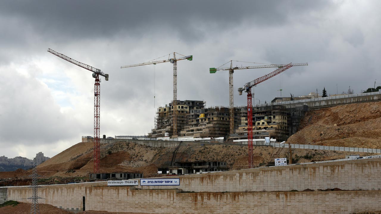 (FILES) This file photo taken on January 27, 2016 shows cranes at a construction site in the Israeli settlement of Ramot built in a suburb of mostly Arab east Jerusalem. Israeli authorities on January 22, 2017, approved building permits for 566 settler homes in annexed east Jerusalem, plans that had been postponed until US President Donald Trump took office, the city's deputy mayor Meir Turjeman said. The new permits are for homes in the settlement neighbourhoods of Pisgat Zeev, Ramot and Ramat Shlomo, according to Turjeman, who also heads the planning committee that approved them. AHMAD GHARABLI / AFP