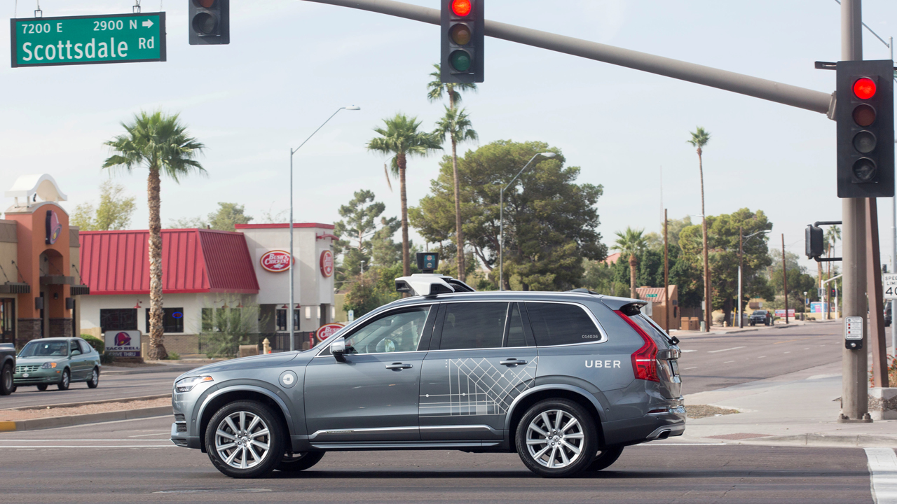 FILE PHOTO: A self driving Volvo vehicle, purchased by Uber, moves through an intersection in Scottsdale