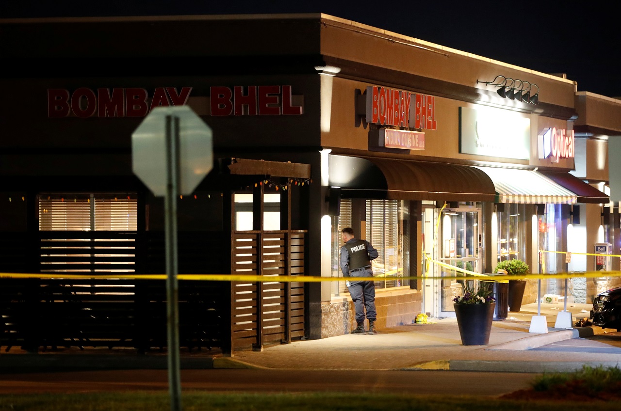 Police officer looks inside Bombay Bhel restaurant in Mississauga