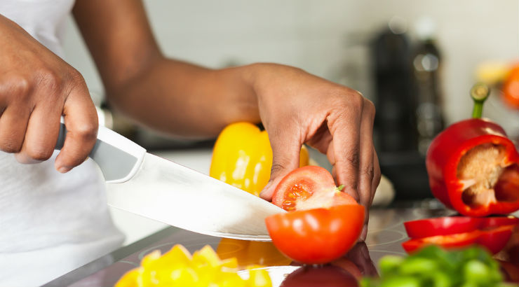 A-black-woman-cutting-a-tomato