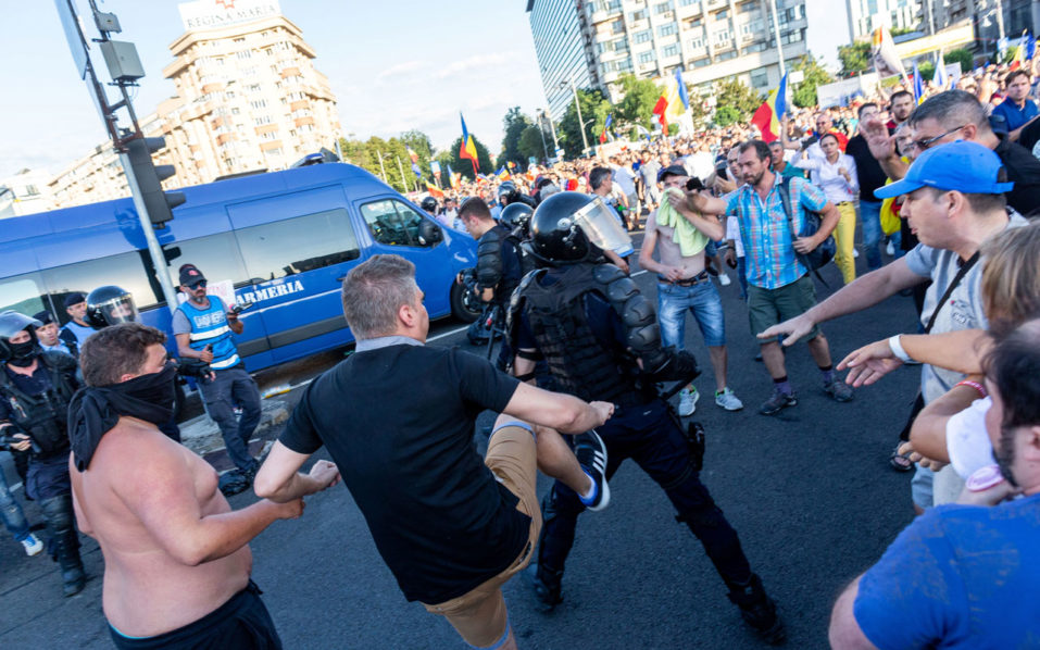 Protesters scuffle with police during a demonstration in Bucharest