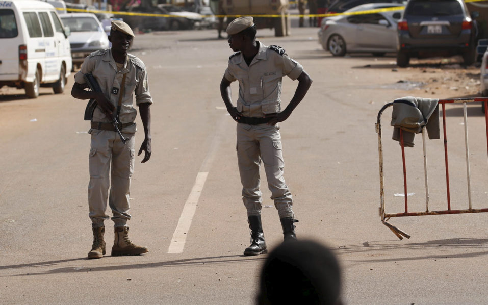 Police officers stand guard at a security barrier in front of the Splendid Hotel in Ouagadougou