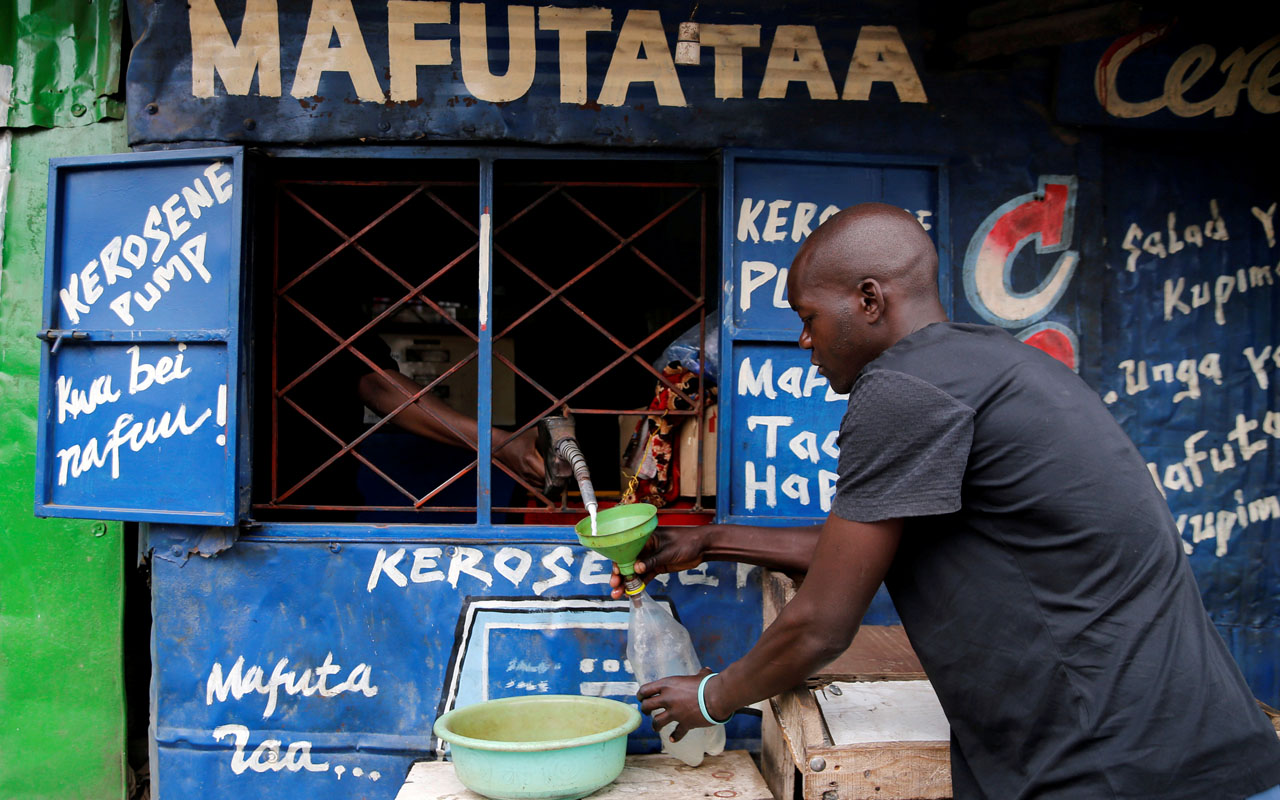 A man fills a bottle with Kerosene in Mathare, in Nairobi