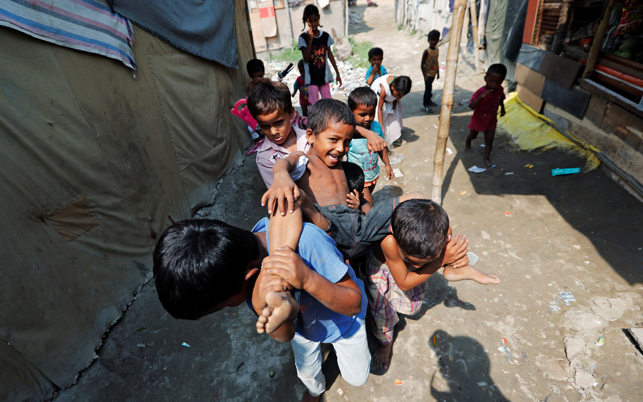 Children from the Rohingya community play outside their shacks in a camp in New Delhi