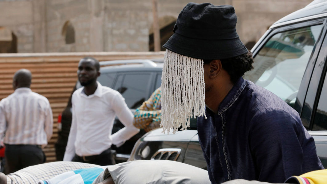 Undercover journalist Anas Aremeyaw Anas prays with others for his slain colleague Ahmed Hussein-Suale, an investigative journalist who was killed by gunmen on Wednesday, at Madina Central Mosque in Accra
