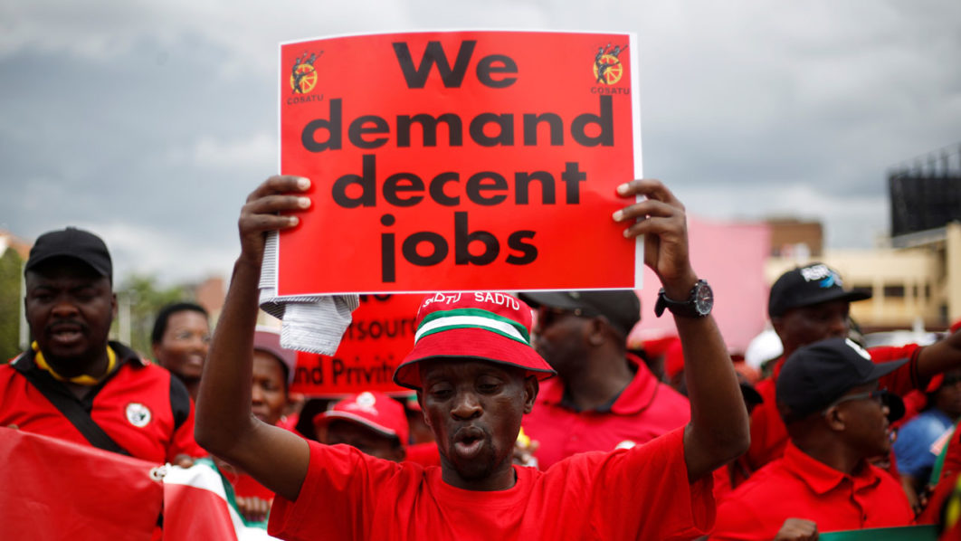 A member of the Confederation of South African Trade Unions (COSATU) holds a placard during a march against job losses in Durban, South Africa