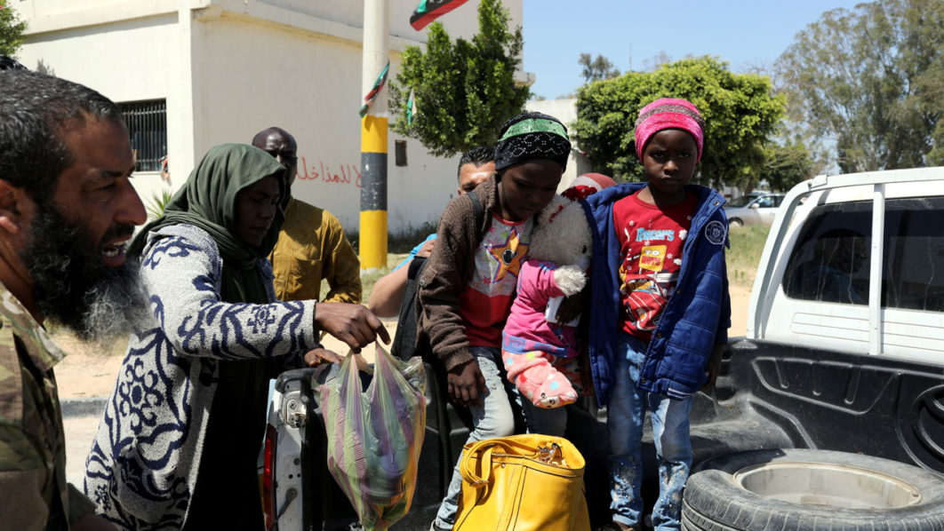 Members of Libyan internationally recognised government forces evacuate an African family during the fighting with Eastern forces, at Al-Swani area in Tripoli