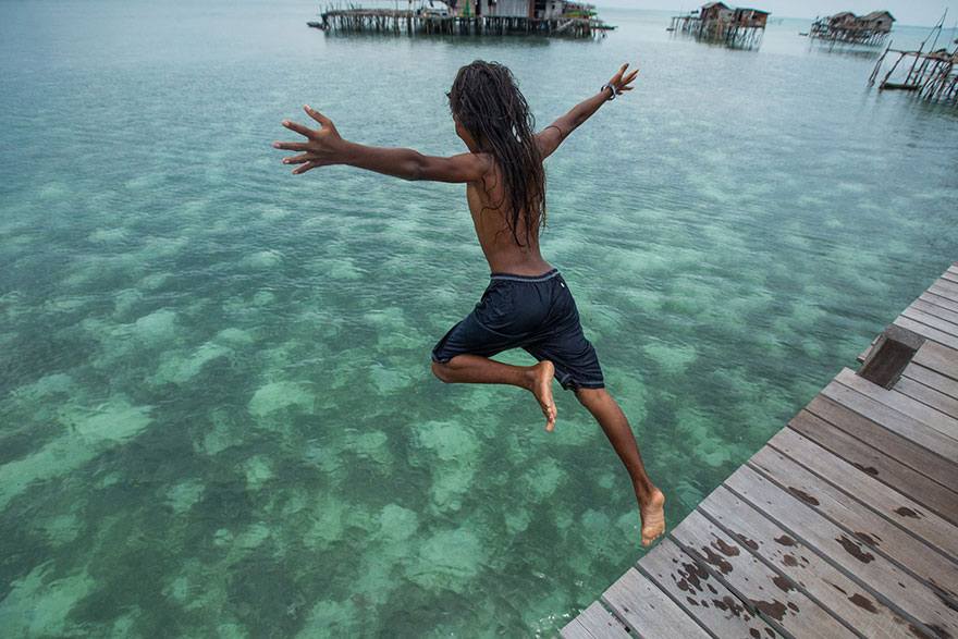 Young Bajau boy diving into the ocean, Photo. Rehahn
