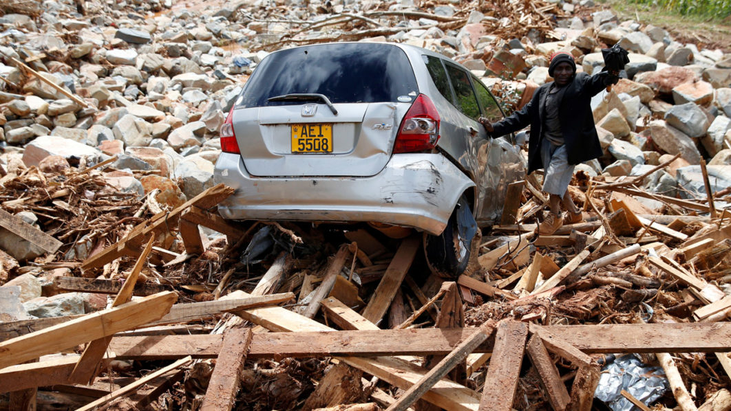 FILE PHOTO: A man gestures next to his car after it was swept into debris left by Cyclone Idai in Chimanimani, Zimbabwe