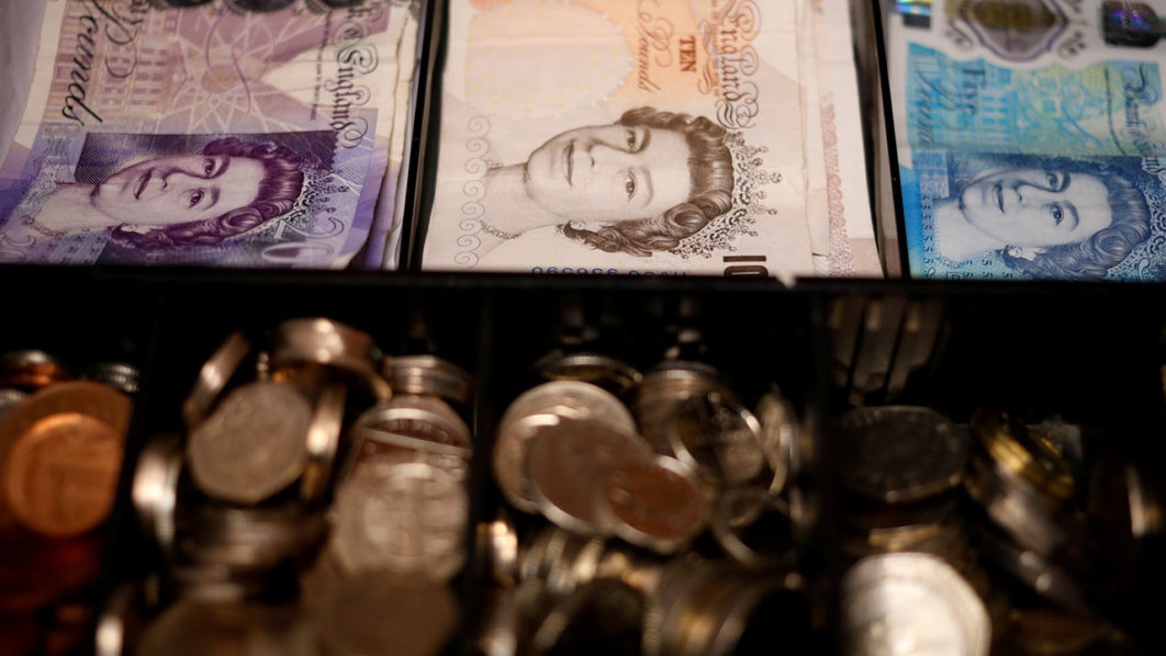 FILE PHOTO: Pound notes and coins are seen inside a cash register in a bar in Manchester, Britain