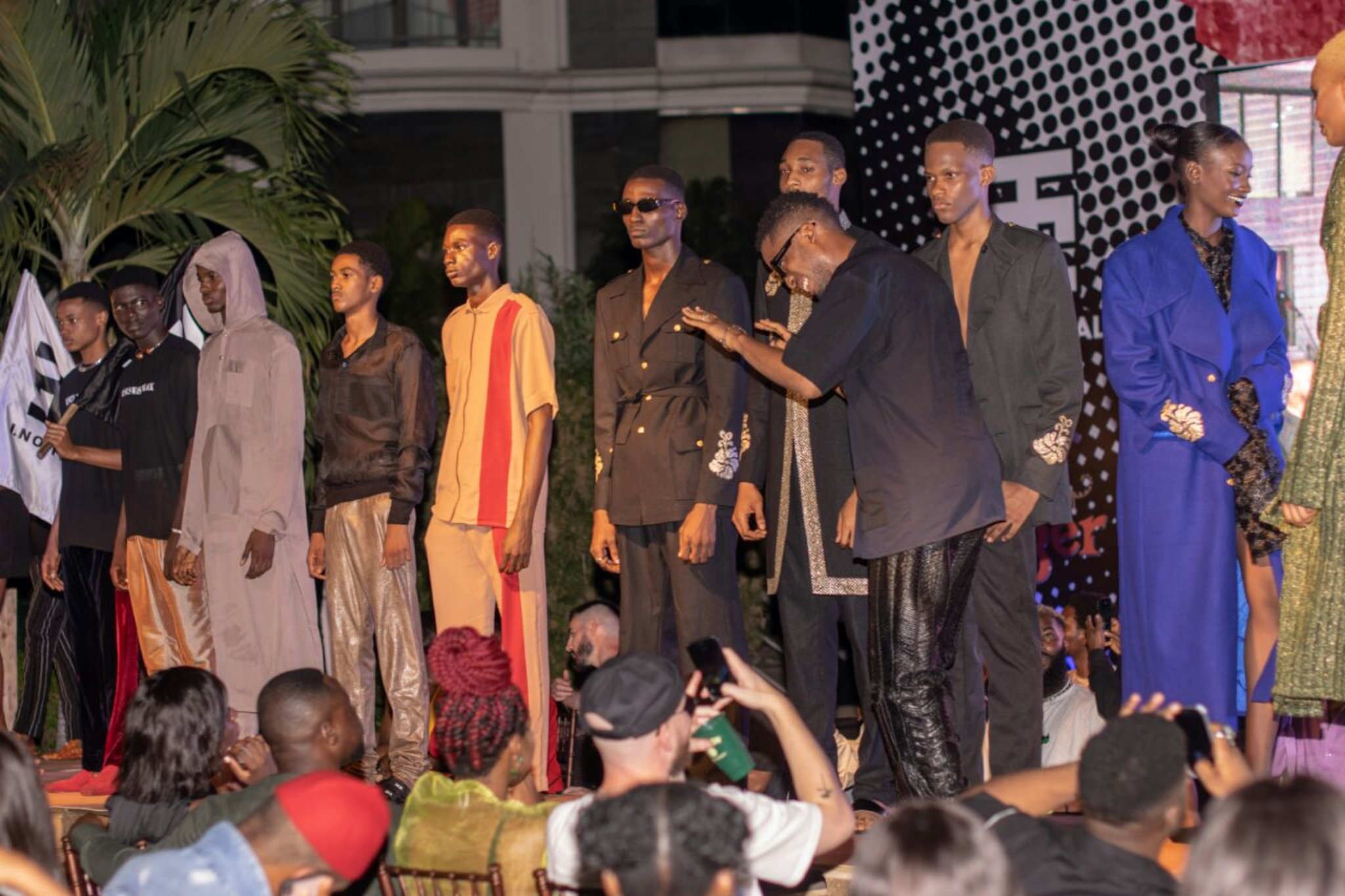 Ifeanyi Nwune on stage with models dressed in I.N pieces