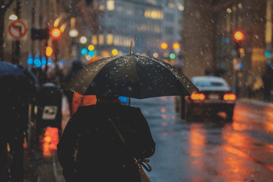 Woman shielded from rain – UNSPLASH