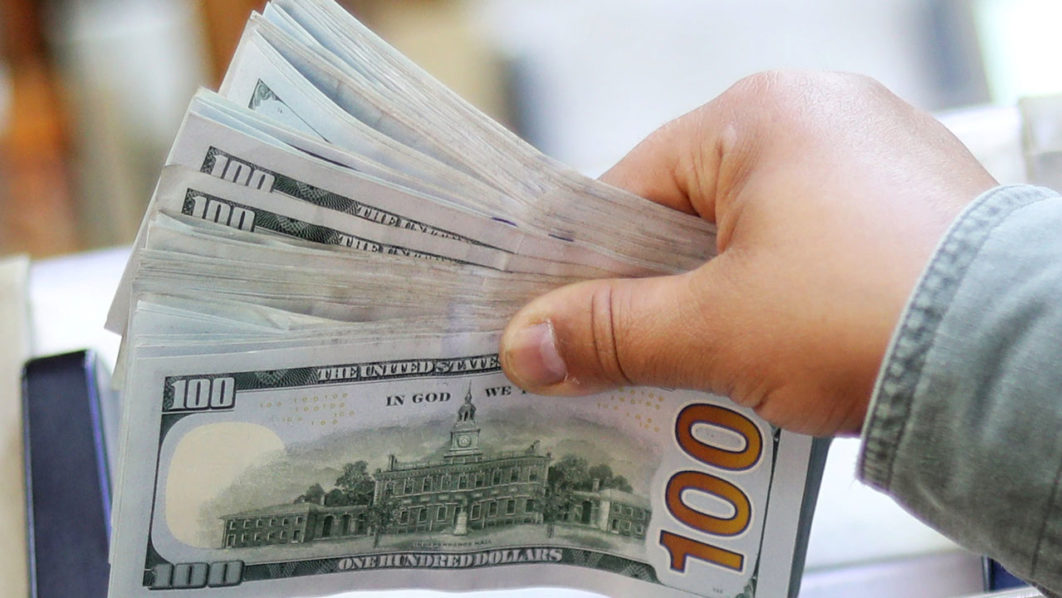 An employee counts U.S. dollar bills at a money exchange office in central Cairo