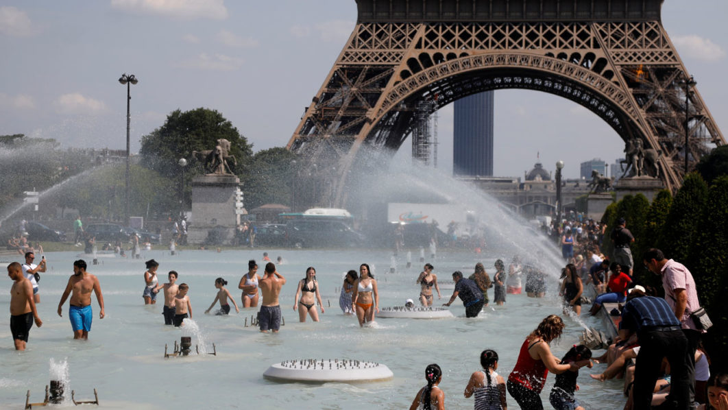 People cool off in the Trocadero fountains across from the Eiffel Tower in Paris as a heatwave hit much of the country