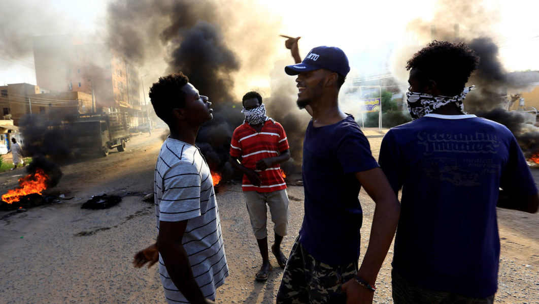 Protesters chant slogans and burn tyres during a demonstration against a report of the Attorney-General on the dissolution of the sit-in protest in Khartoum