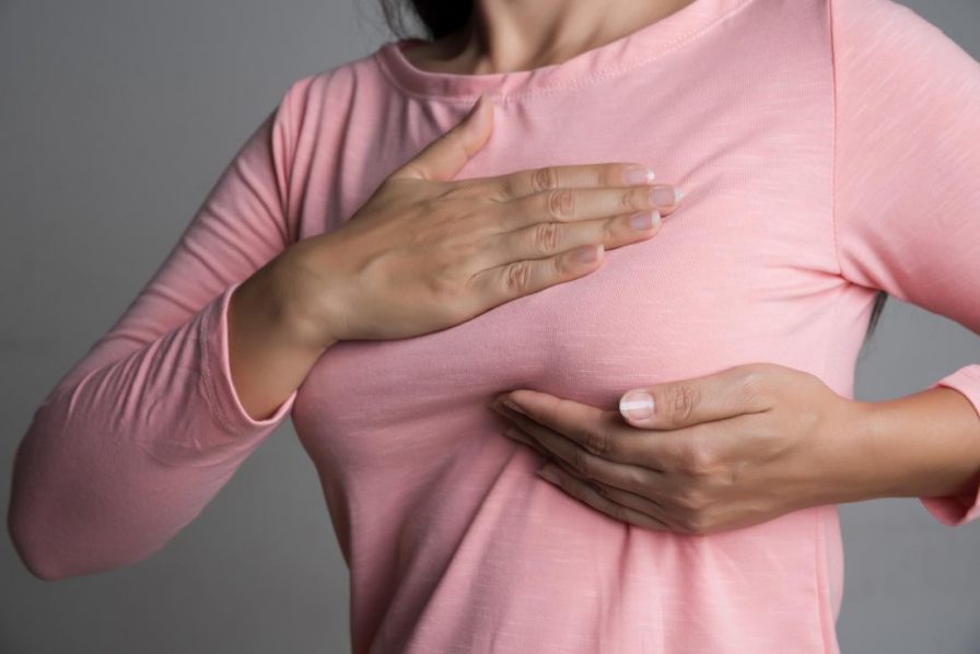 A woman checking her breasts for lumps