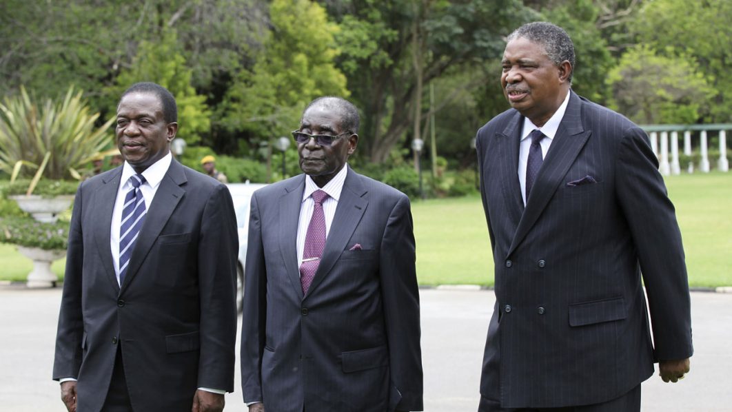 Zimbabwe’s President Robert Mugabe is seen with Vice Presidents Phelekezela Mphoko (R) and newly-sworn in Emmerson Mnangagwa (L) at the State House in Harare