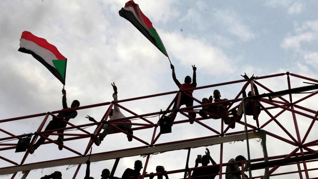 Sudanese civilians wave their national flags during celebrations of the signing of the Sudan’s power sharing deal in Khartoum