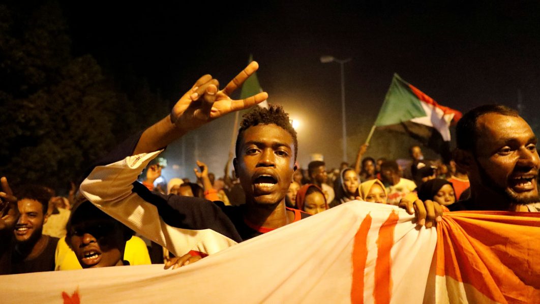 FILE PHOTO: Sudanese people chant slogans and wave Sudanese flags during a demonstration in Khartoum