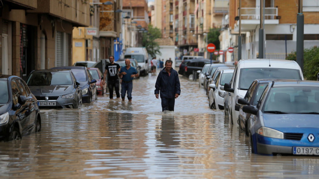 People wade through a flooded street as torrential rains hit Orihuela