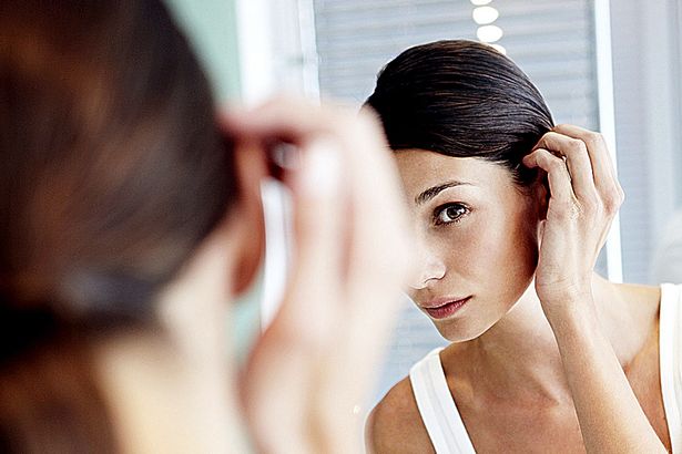 Young-woman-carefully-checking-her-hair