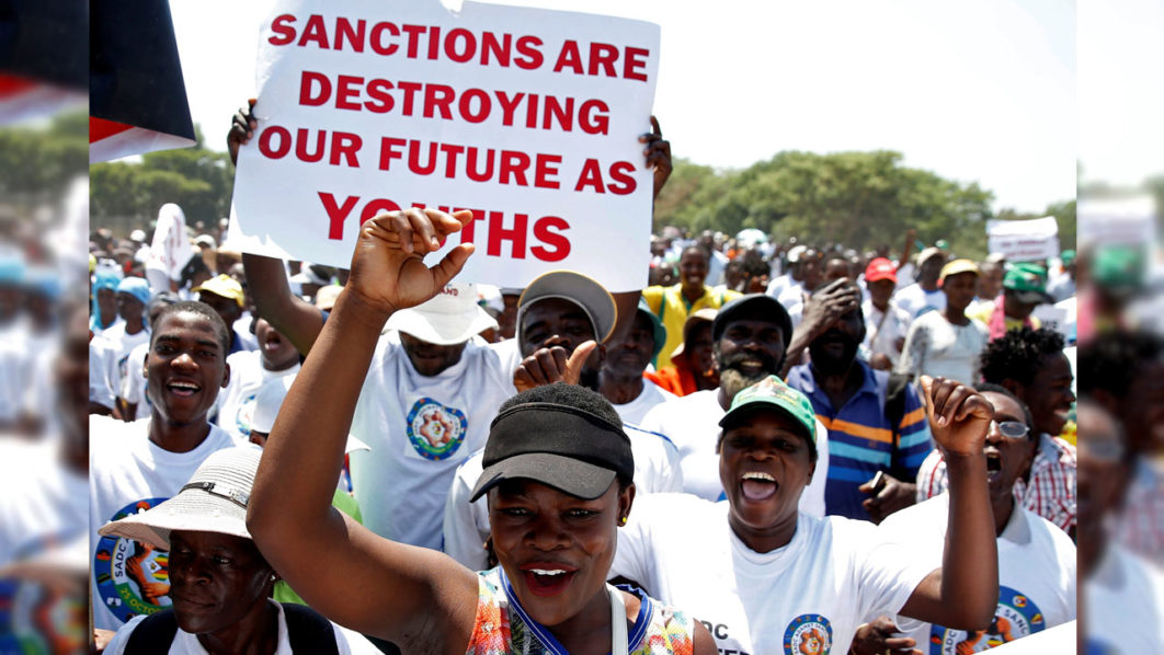Government supporters chant slogans as they march against Western sanctions at a rally in Harare