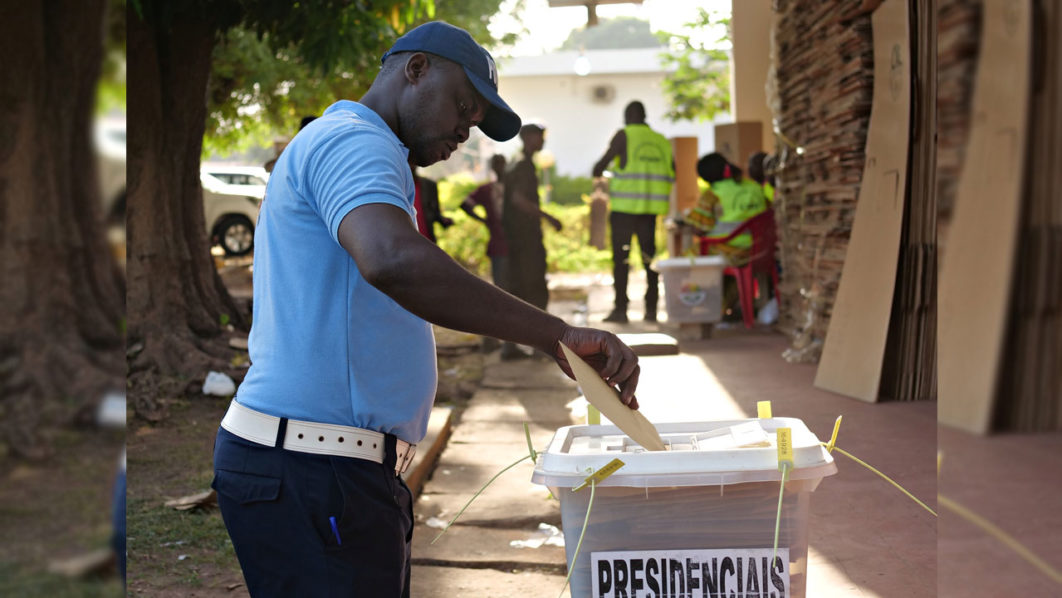 A police member casts his vote ahead of the presidential election at the National Election Commission headquarter in Bissau