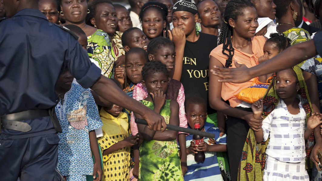 The crowd is held back by a police line as Pope Benedict XVI approaches on the street in Benin’s main city Cotonou
