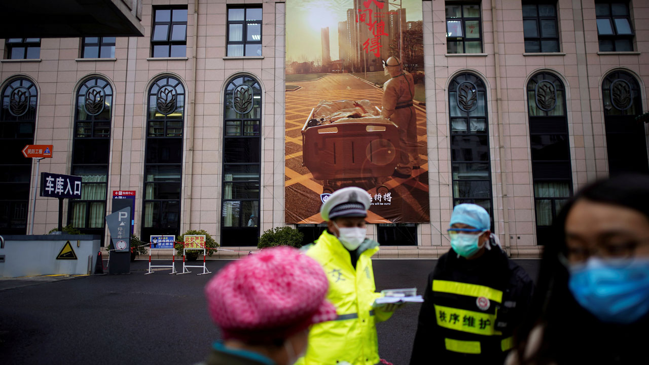 FILE PHOTO: People wearing protective face masks are seen outside a hospital following an outbreak of coronavirus (COVID-19), in downtown Shanghai,