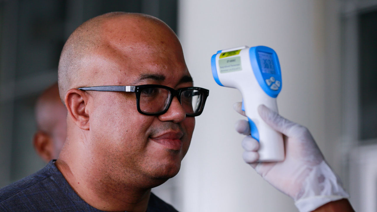 Dr. Chikwe Ihekweazu, the Director General of NCDC has his temperature checked during a diplomatic meeting at the Ministry of Foreign Affairs in Abuja