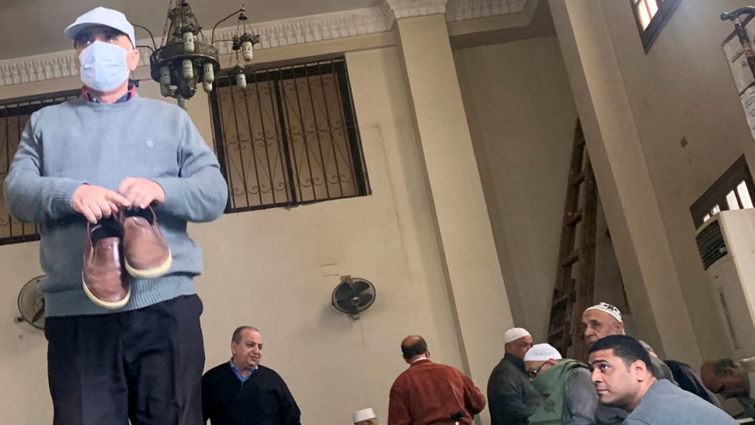 People look at a man wearing a protective mask as a means of prevention against the coronavirus disease (COVID-19) at the Al Rahman mosque, after Friday prayers, in the southern suburb of Maadi, on the outskirts of Cairo