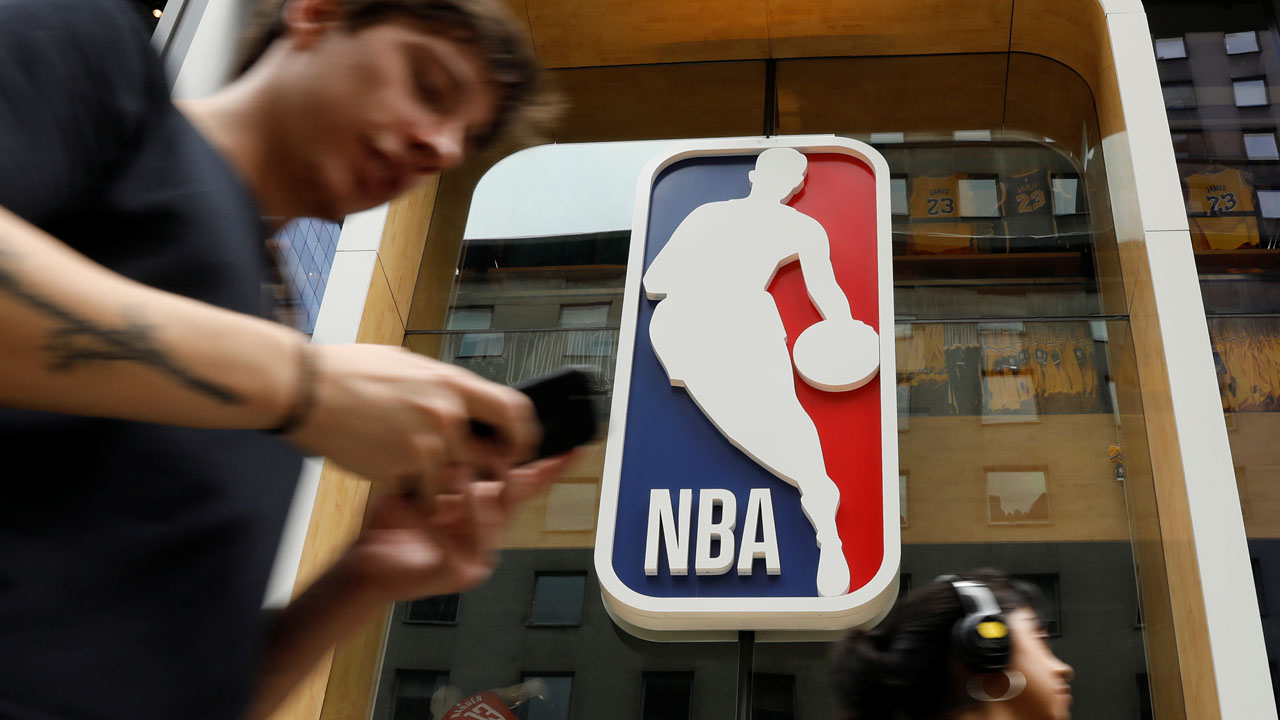 The NBA logo is displayed as people pass by the NBA Store in New York