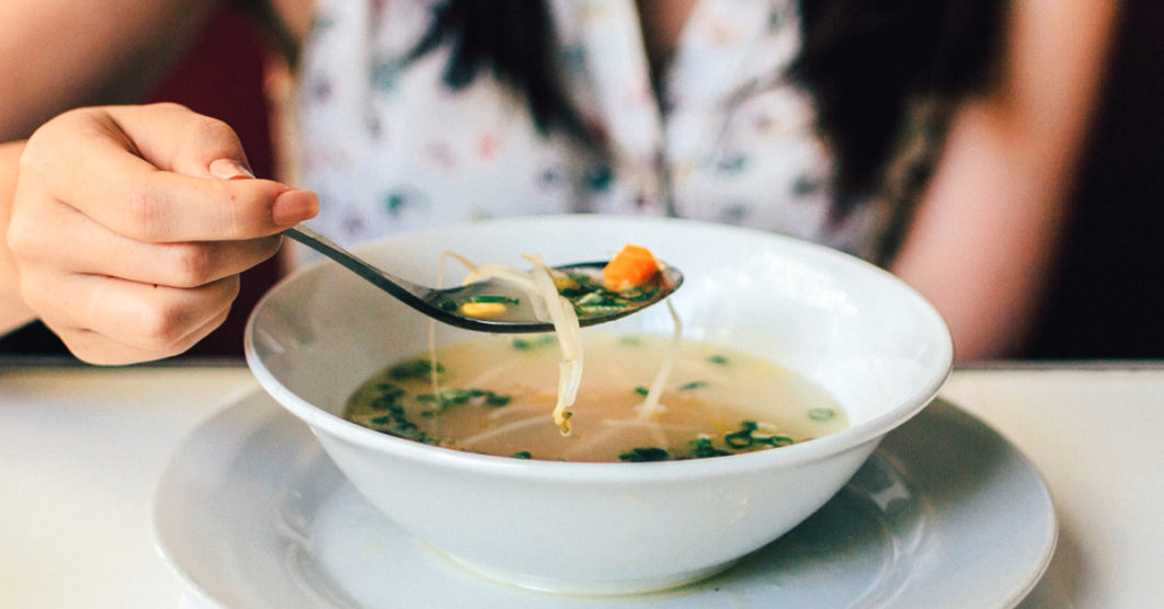 Woman eating chicken broth Photo – Healthline