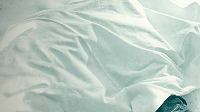Dead man in the snow covered with a blanket