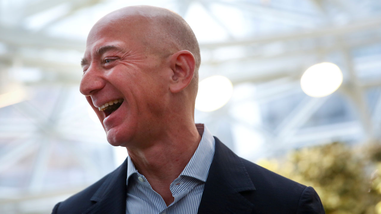 FILE PHOTO: Amazon founder and CEO Jeff Bezos laughs as he talks to the media while touring the new Amazon Spheres during the grand opening in Seattle