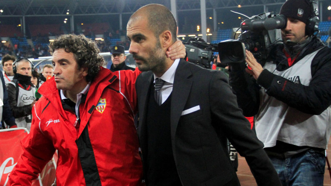 FILE PHOTO: Almeria’s coach Lillo and Barcelona’s coach Guardiola leave the pitch at the end of their Spanish first division soccer match against Barcelona in Almeria.
