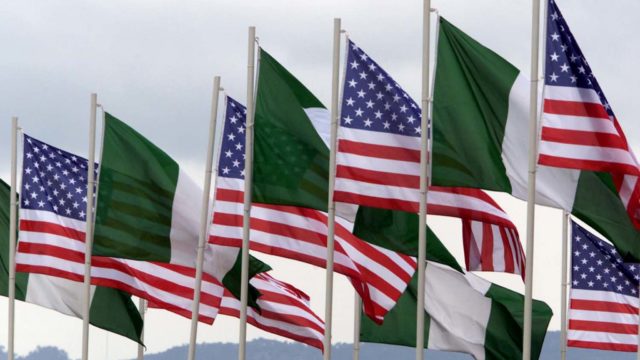 AMERICAN AND NIGERIAN FLAGS FLY NEXT TO EACH OTHER.